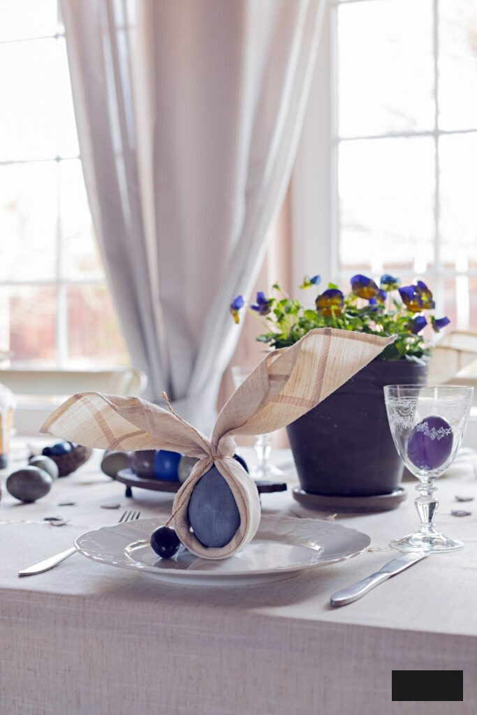 Easter table setting with blue eggs and potted violets