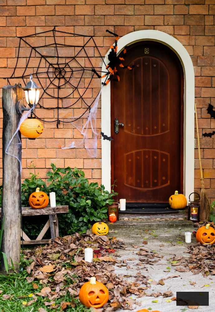 Halloween pumpkins and decorations outside a residence
