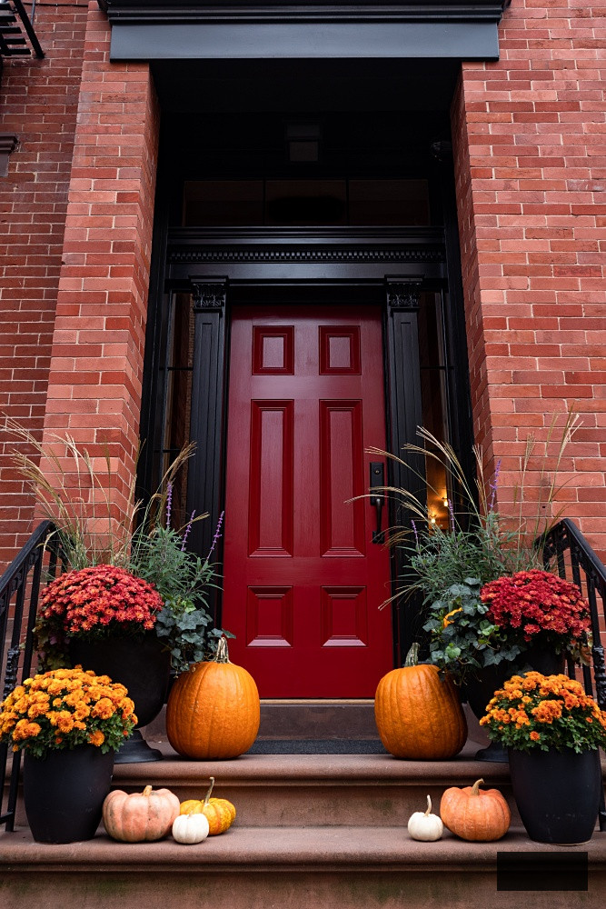 Vibrant Pumpkins and Flowers on the Stairs of a Classic Brownstone