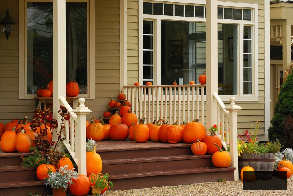 An array of large pumpkins on a front porch - outdoor Halloween decorations