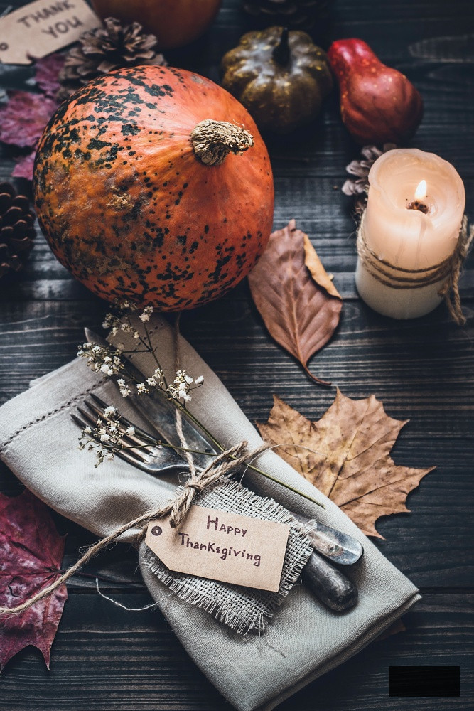 Thanksgiving decoration with cutlery and napkin on the wooden table.
