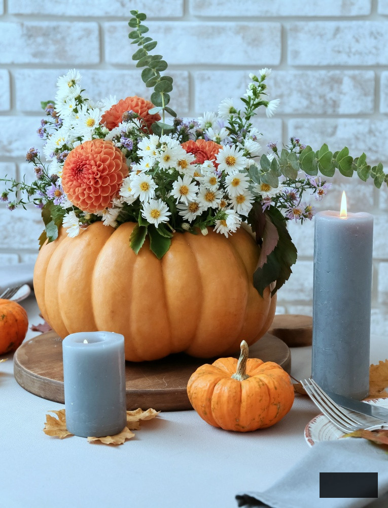 Lovely bouquet of autumn flowers in a pumpkin for table centerpiece