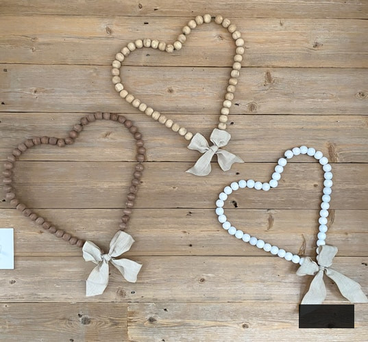 Looking for easy ways to decorate for Valentine's Day? These DIY Wood Bead Valentine Wreaths turn dollar store items into 3 pretty wreaths.