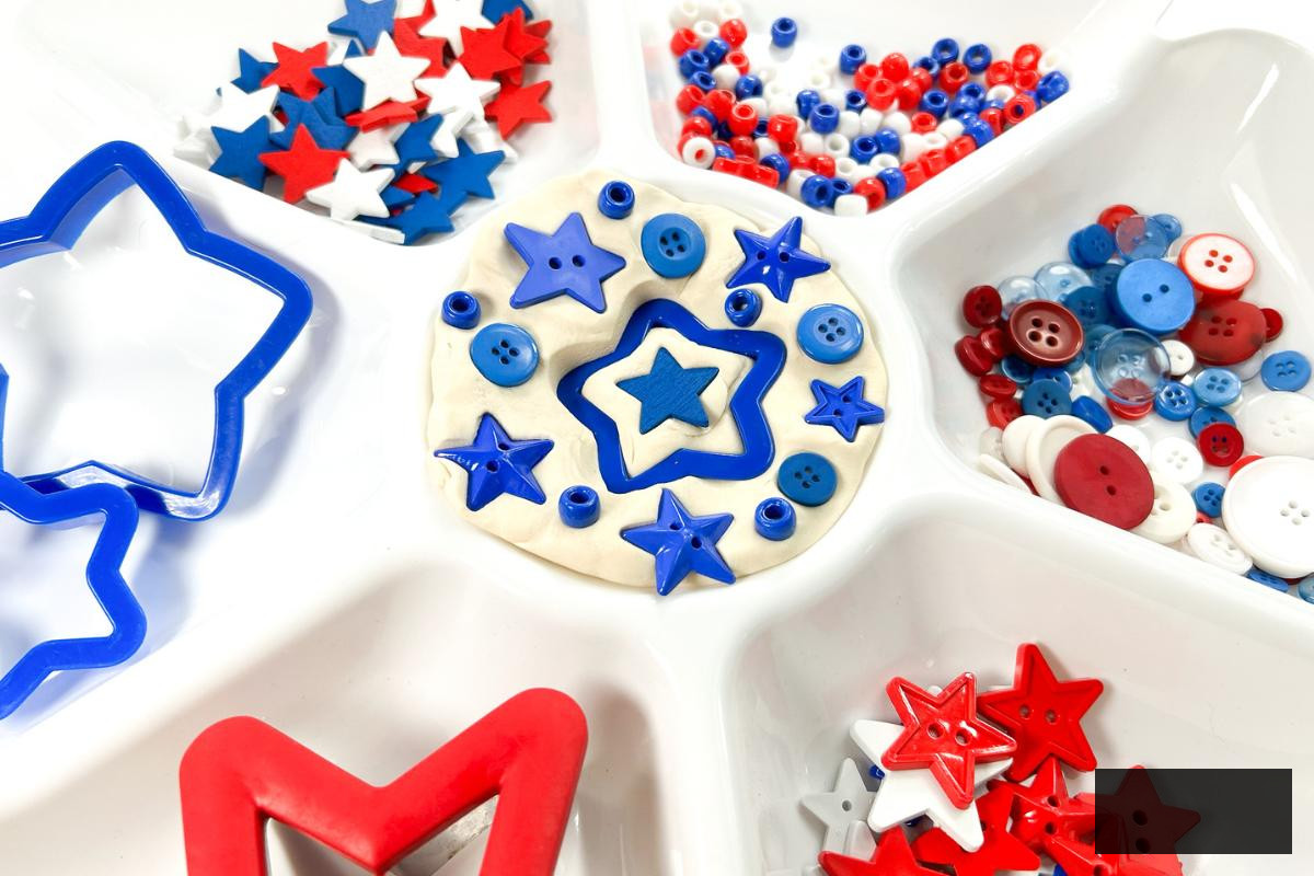 Azure sorting stars, buttons, and cookie cutters in a sensory play activity for children for Independence Day.