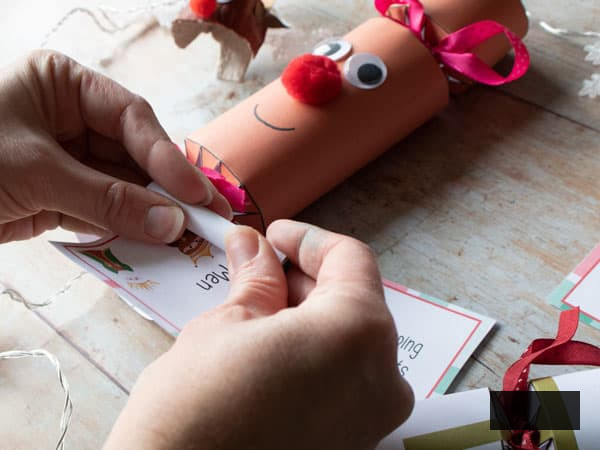 rolling up the charade to fit in the christmas cracker