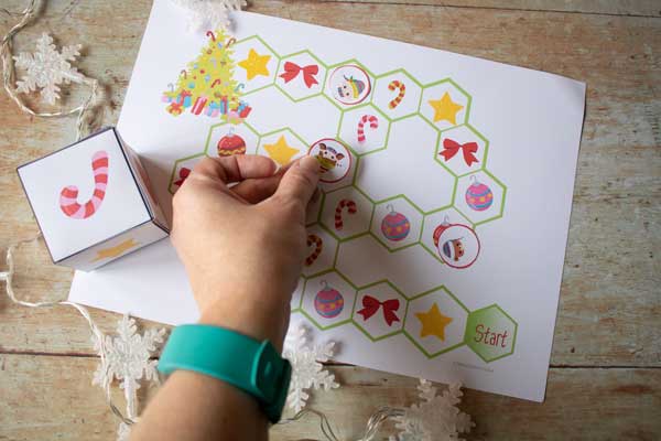 moving places on the christmas printable game while playing with preschoolers