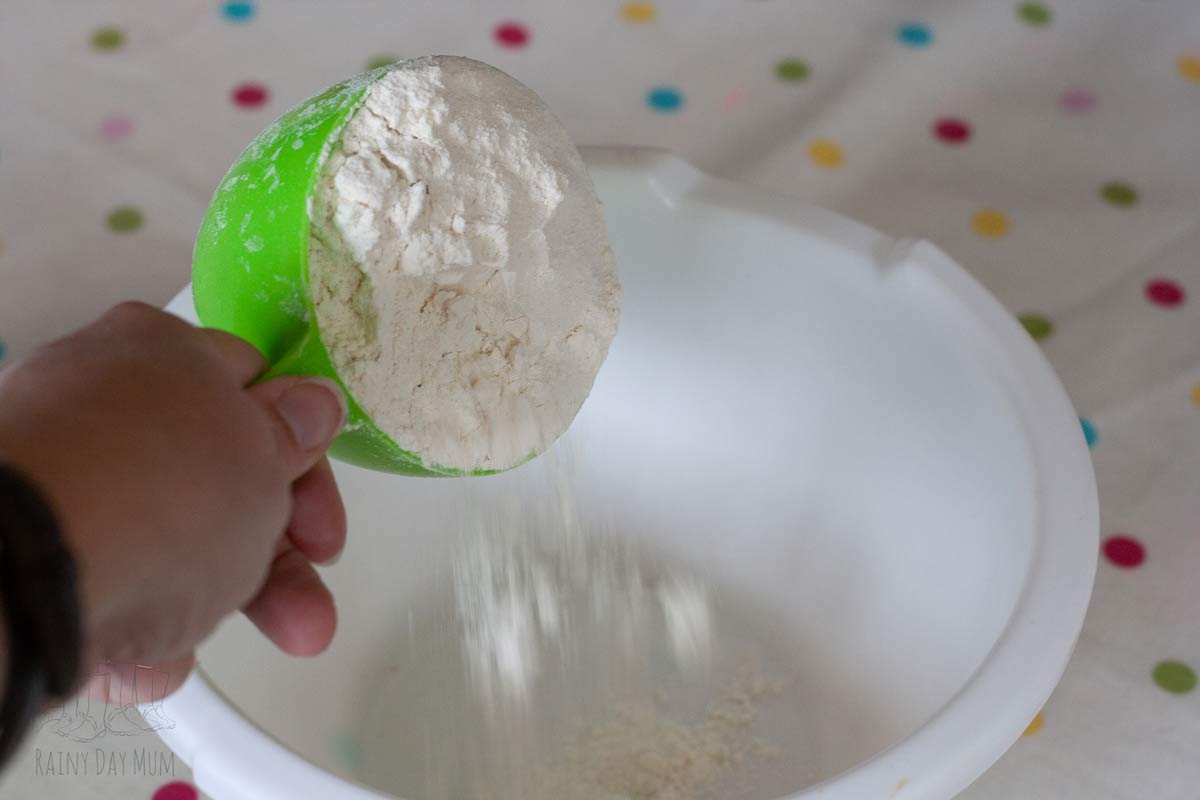 pouring flour from a measuring cup into a mixing bowl
