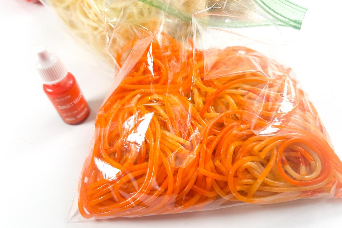 Dyed spaghetti inside a plastic pouch for sensory play.