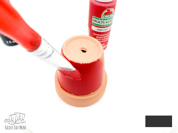 painting a clay pot with acrylic craft paints