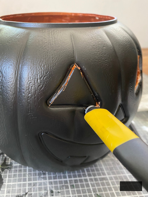Craft chic Halloween decorations with a DIY Pottery Barn Jack-O-Lantern replica. Achieve the upscale appearance for under $5 using plastic buckets, paint, and LED candles.