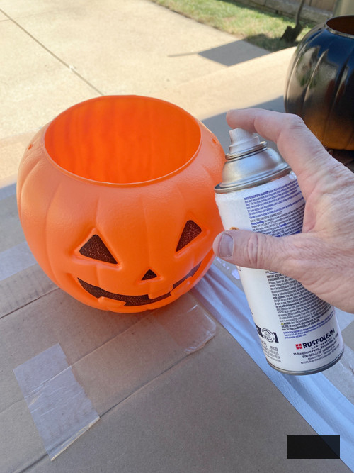 Craft chic Halloween decorations with a DIY Pottery Barn Jack-O-Lantern replica. Achieve the upscale appearance for under $5 using plastic buckets, paint, and LED candles.