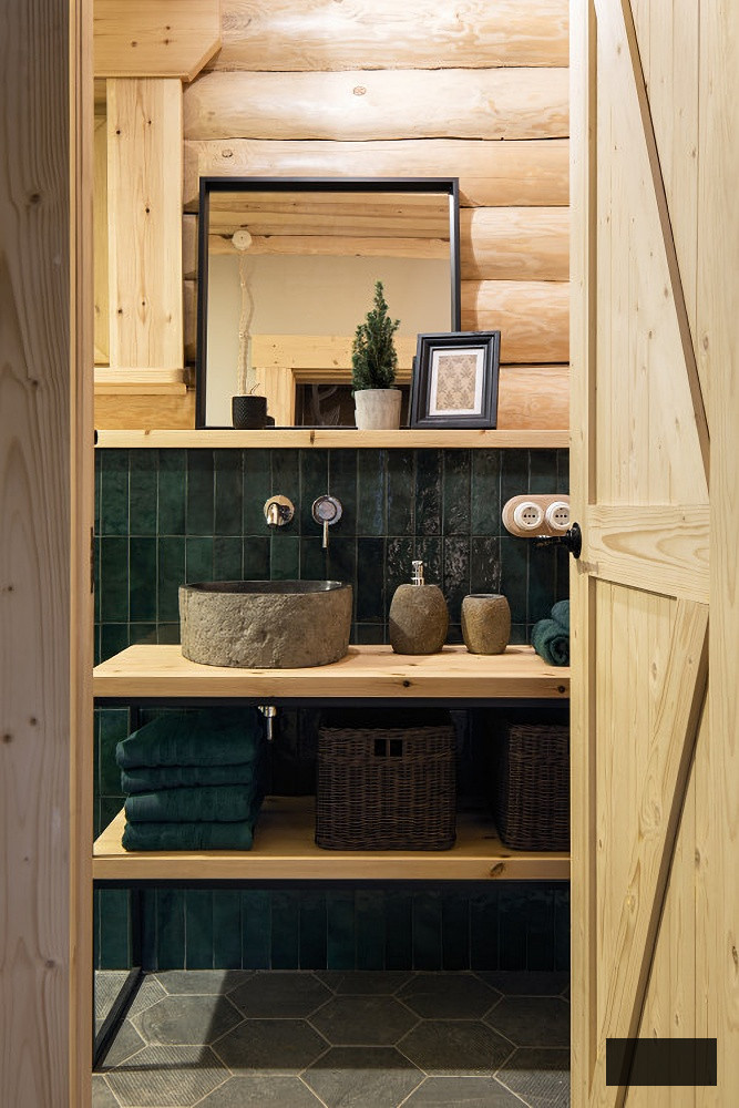Powder room with dark green tile and light log walls