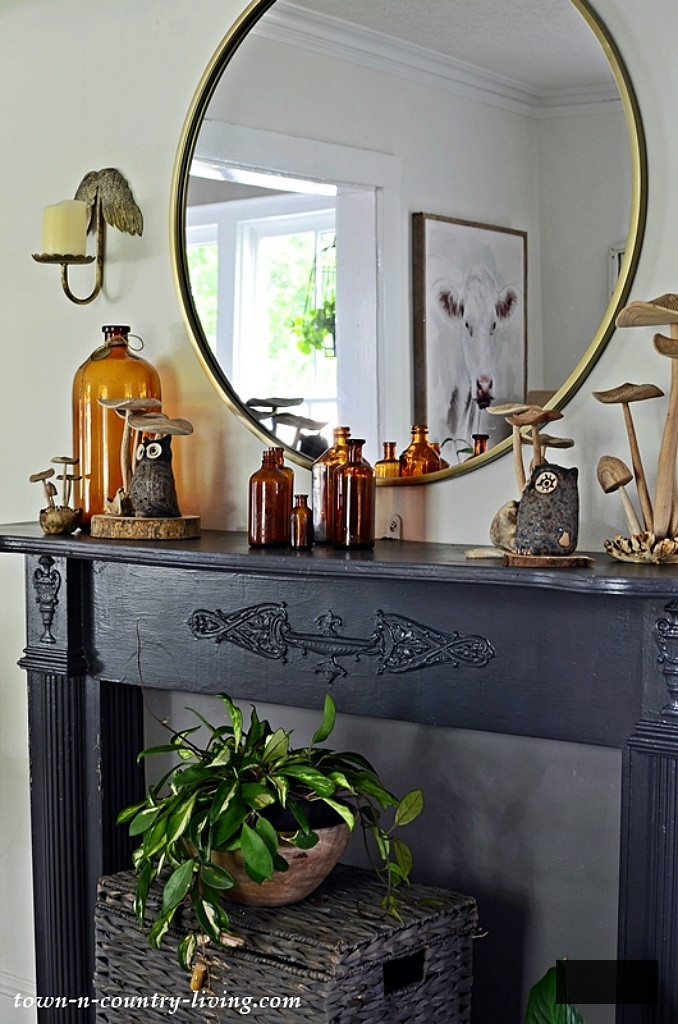 black mantel adorned with amber bottles and wood mushrooms