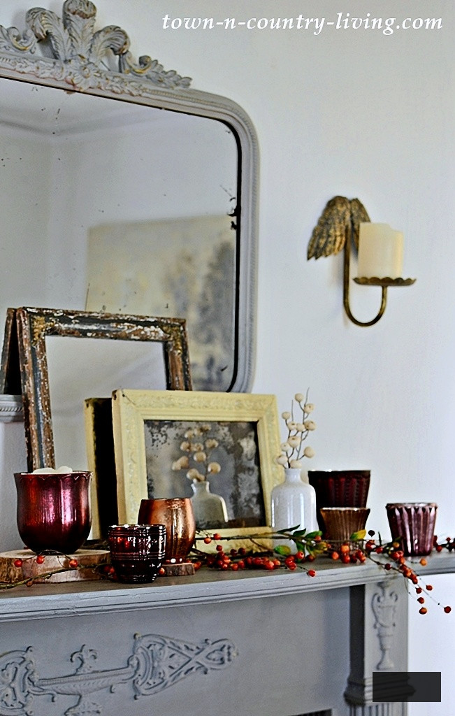 gray mantel with vintage mirrors and burgundy candles