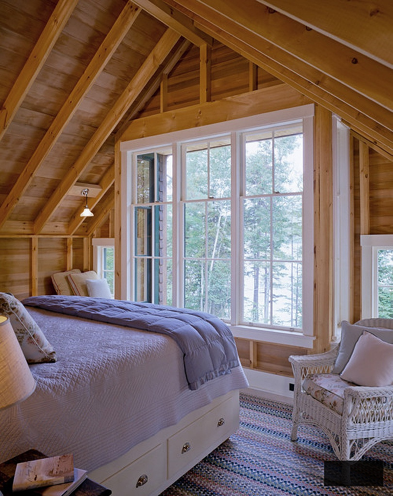 cabin bedroom with blue bedding and white wicker chair