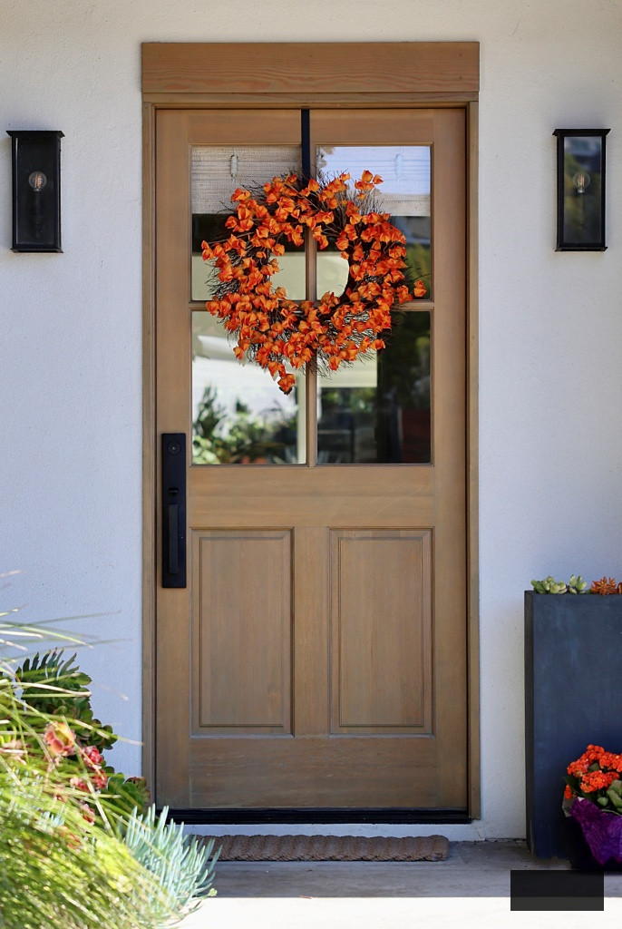 Natural wood front door with autumn wreath