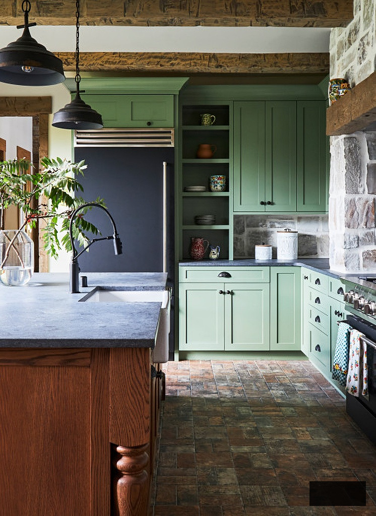 country kitchen with green cabinets and brick floor