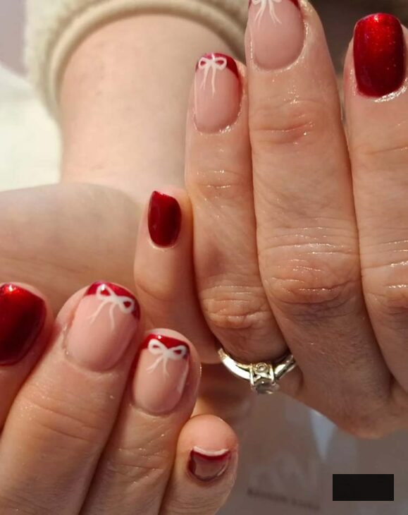 glittery red nails with white bow design on short square nails for christmas
