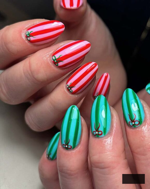 pink and red striped nails with green striped nails for Christmas with tiny bows