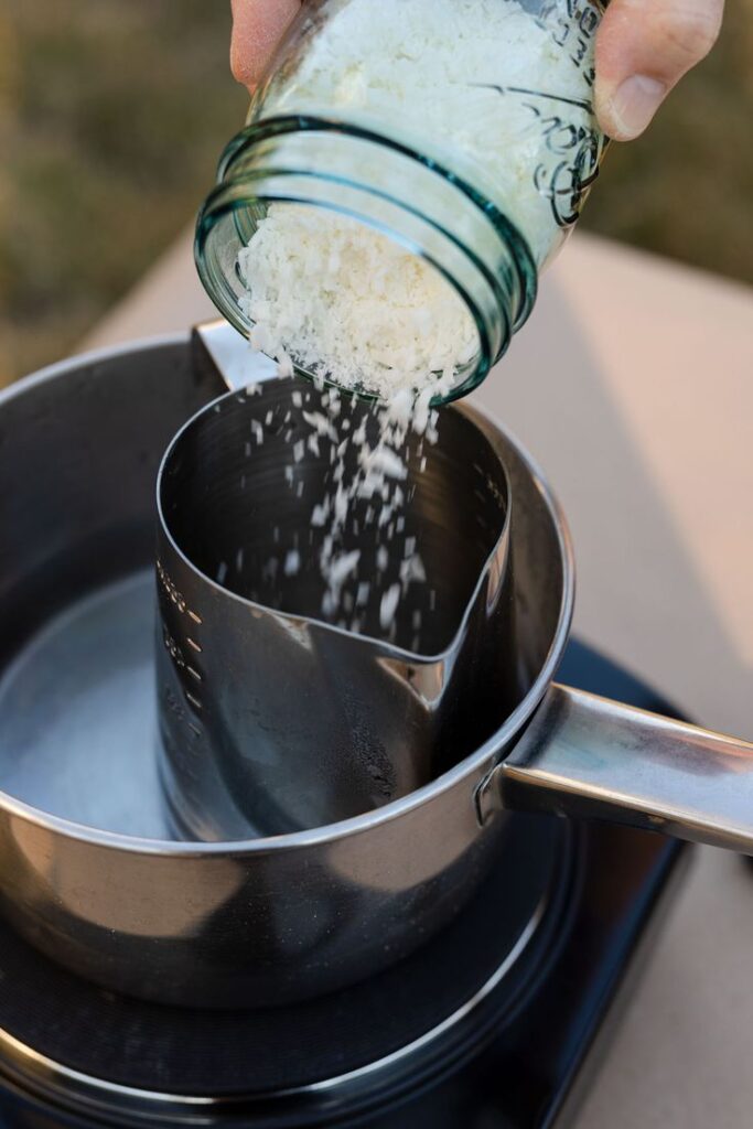 Melting wax in a metal pouring pitcher for homemade candle making