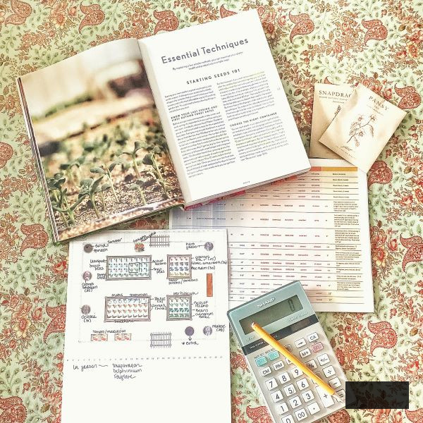  strategizing next year's garden with garden book, calculator, pencil, sketches, and journal entries