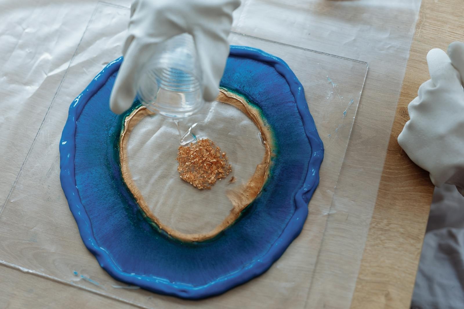 Resin art blue pigment and glitter pour Landscape snapshot of resin art being poured with blue pigment and glitter on a work surface. | Sky Rye Design Landscape snapshot of resin art being poured with blue pigment and glitter on a work surface.