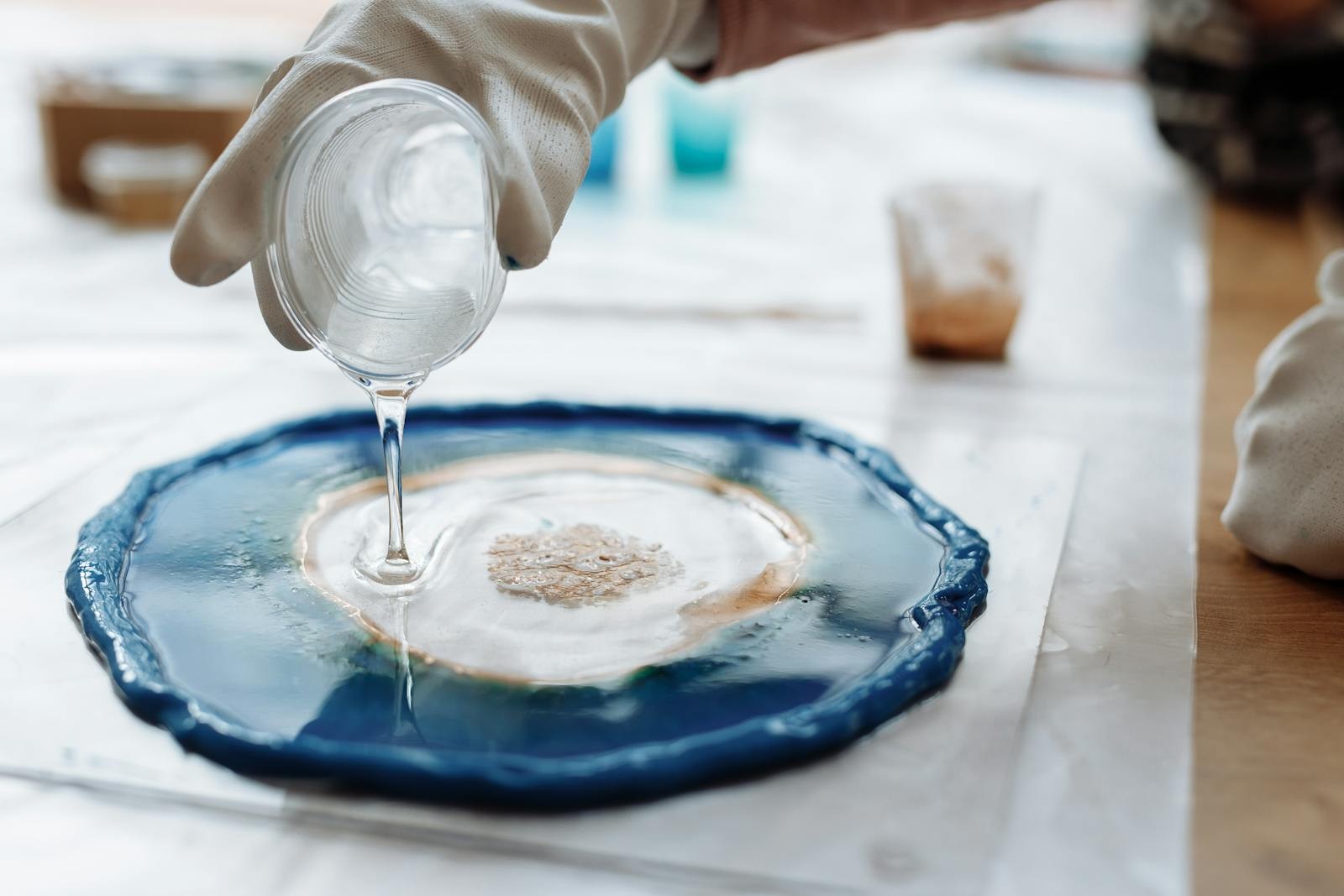 Resin art detail with gloves and mixing cup Landscape detail photo of gloved hands working with resin art materials and a mixing cup. | Sky Rye Design Landscape detail photo of gloved hands working with resin art materials and a mixing cup.