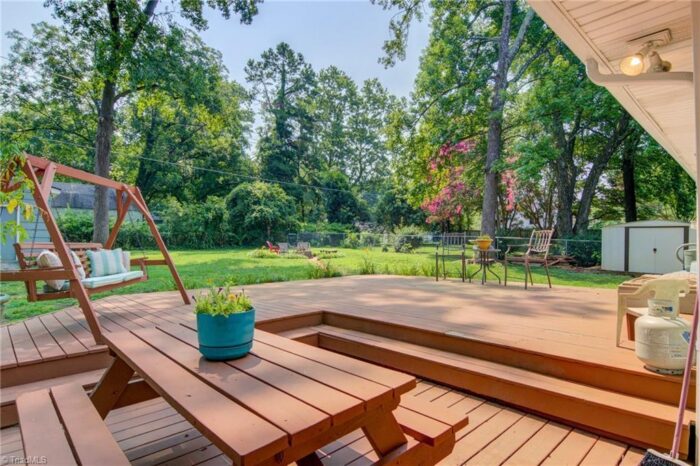 Deck traseiro de dois níveis com balanço manchado e mesa de piquenique