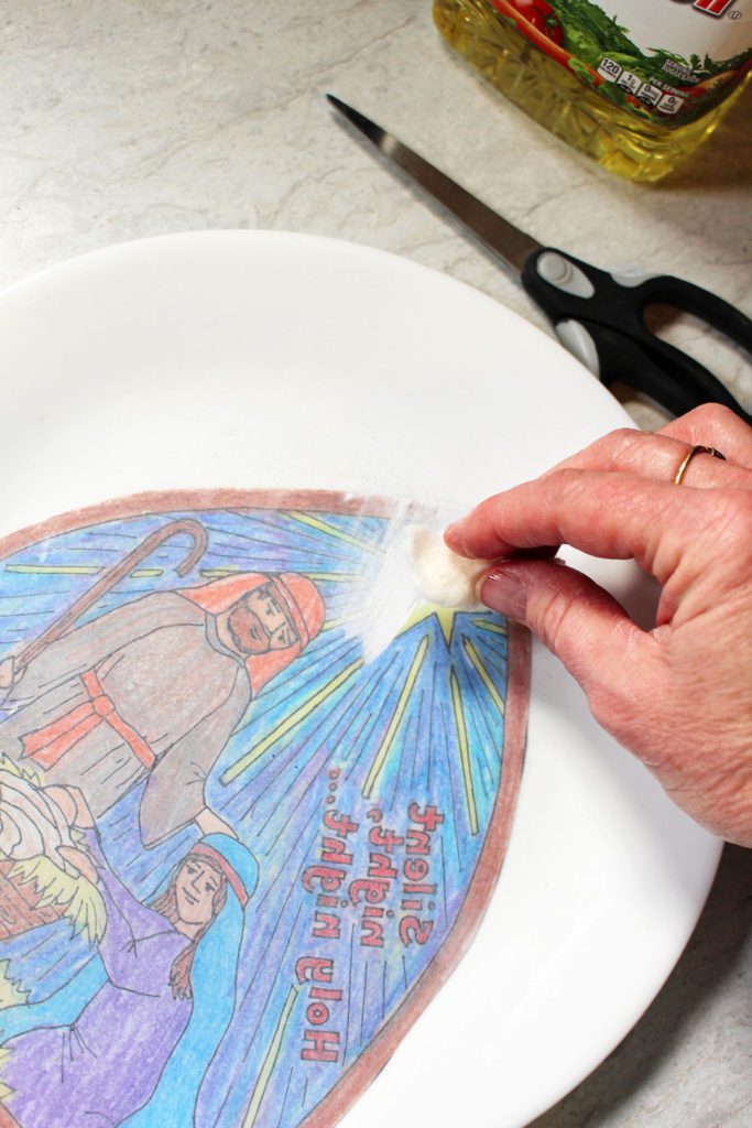 Limpando o óleo na parte de trás da página para colorir para um efeito de vitral.
