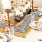 Uma mesa com pratos de comida sobre um prato, com caminho de mesa e toalha