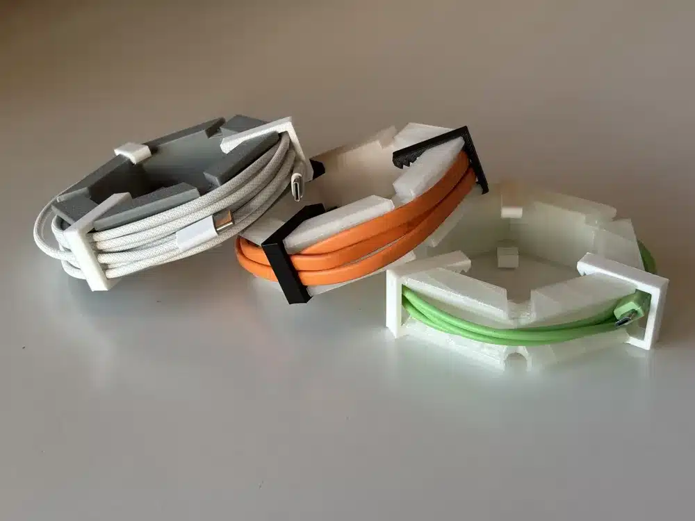 Useful 3D printed cable holders keeping coiled cords separated on a white surface