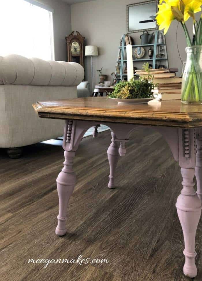 Uma sala de estar cheia de móveis e um vaso de flores sobre uma mesa