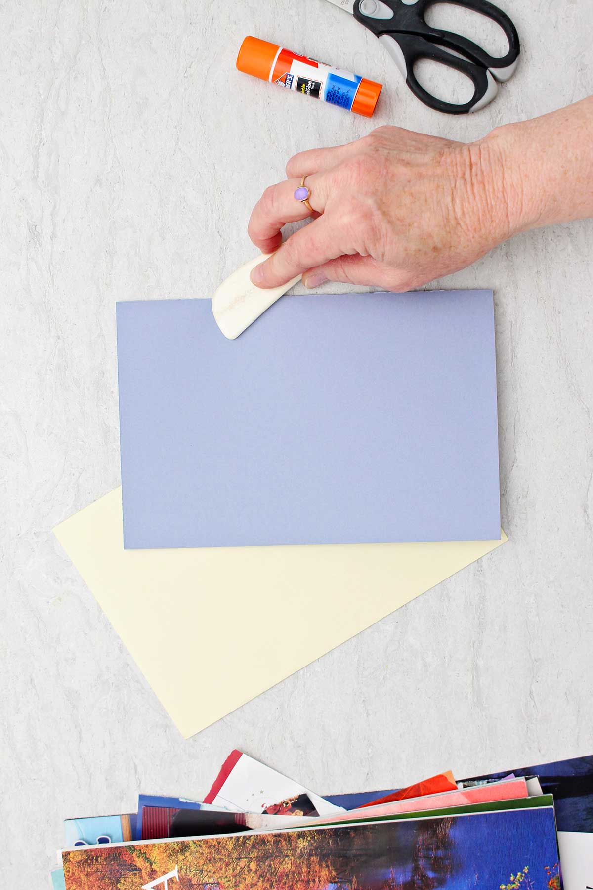 Pessoa usando um marcador para dobrar um pedaço de papel roxo para o cartão do Dia dos Pais.