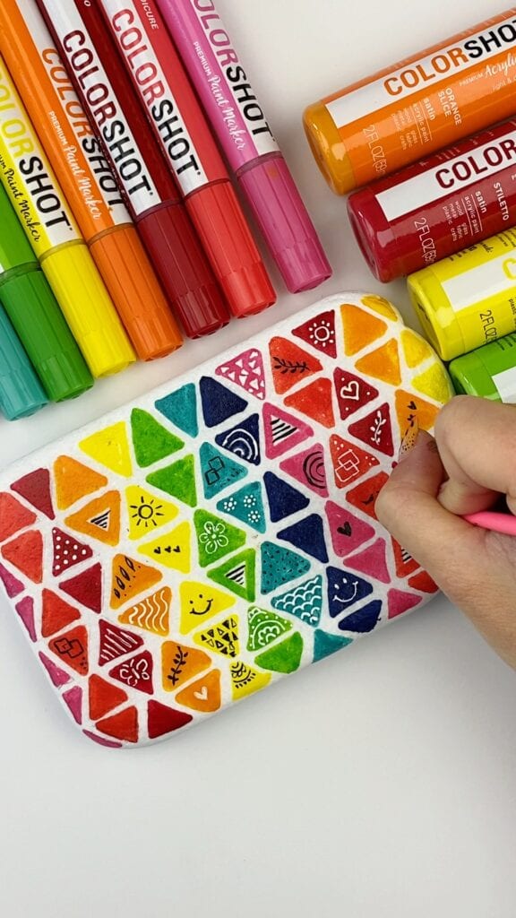 Ideias para sua pedra doodle - nesta foto os doodles estão sendo criados. Exemplos incluem um rosto sorridente e um coração.