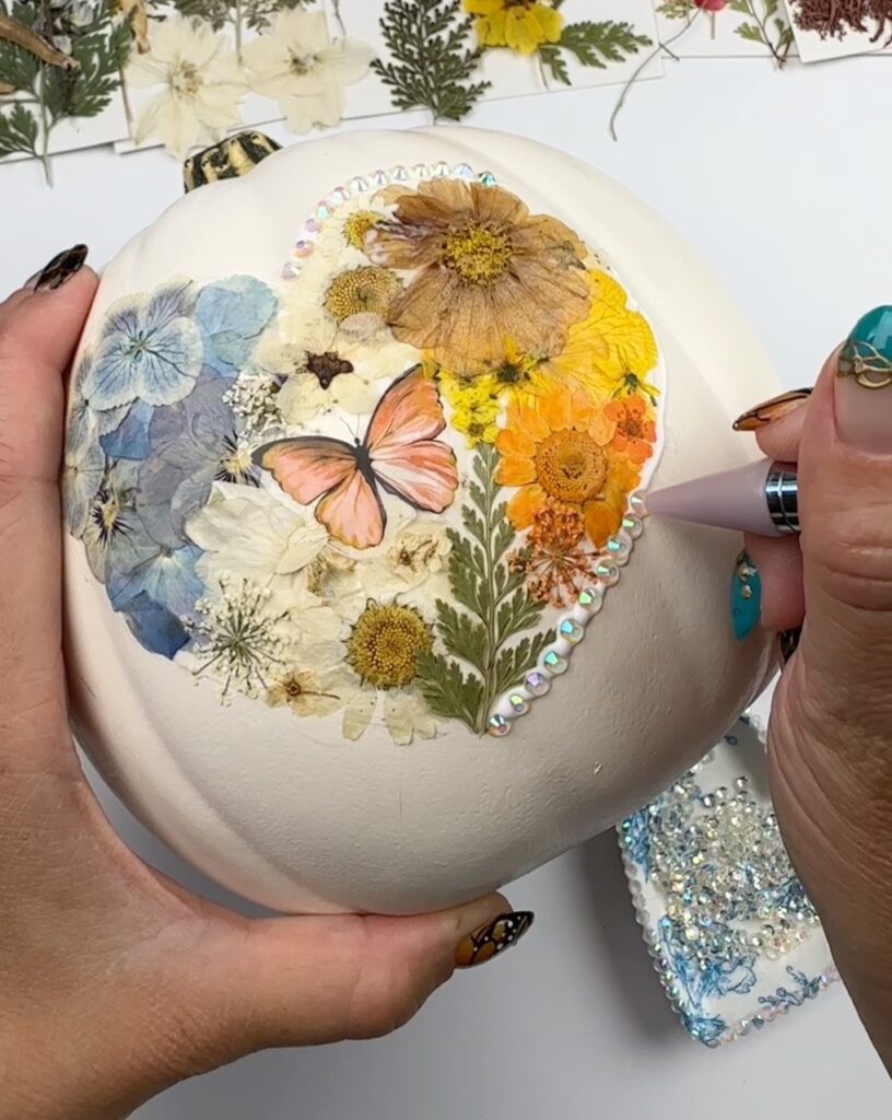 strass adicionados à abóbora decorada com flores prensadas