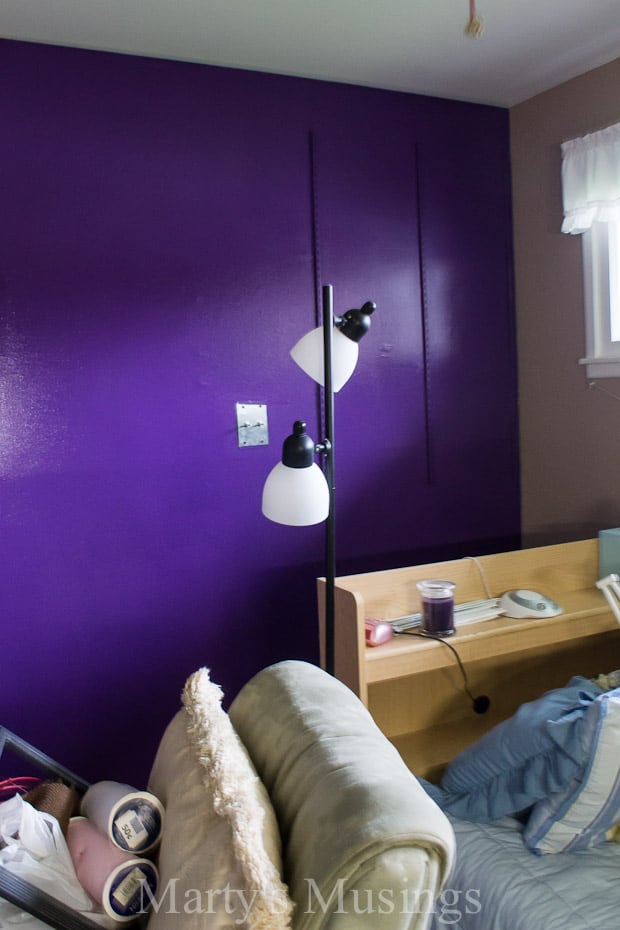 Um quarto com uma cama e uma mesa em um cômodo