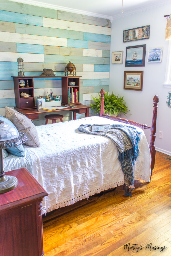 Cama vintage com roupa de cama branca em uma parede de tábuas litorânea