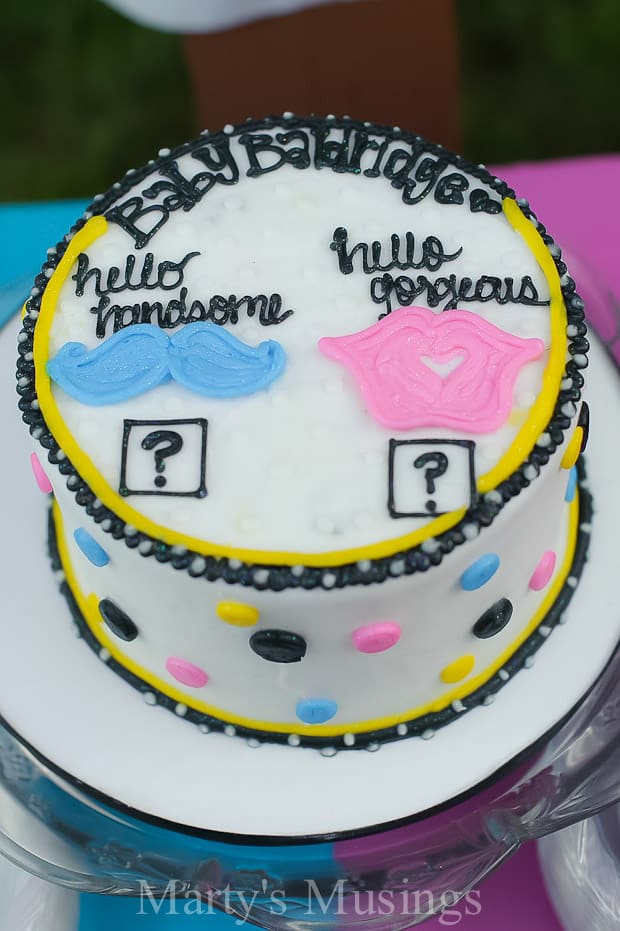 Bolo de revelação do gênero com decorações azuis, rosas e pretas