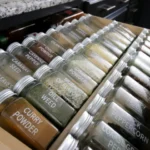 Potes de tempero transparentes com etiquetas em uma gaveta de cozinha