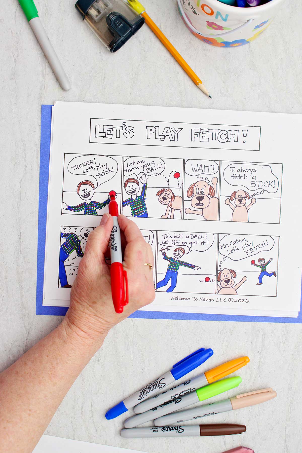 Uma pessoa colorindo uma bola em uma tira de quadrinhos sobre um garoto e seu cachorro em vermelho.