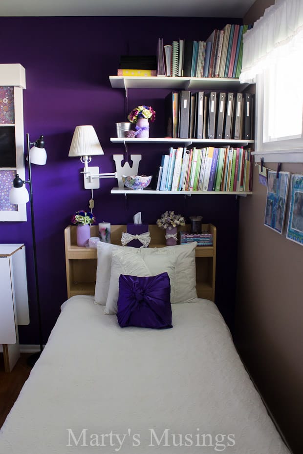 Um quarto com uma cama e uma mesa em um pequeno espaço