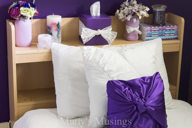 Uma cama de casal com uma flor roxa