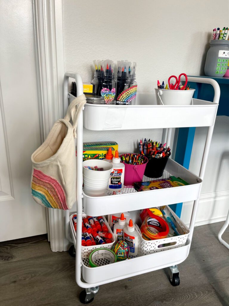 Carrinho de organização branco para quarto de artesanato repleto de suprimentos