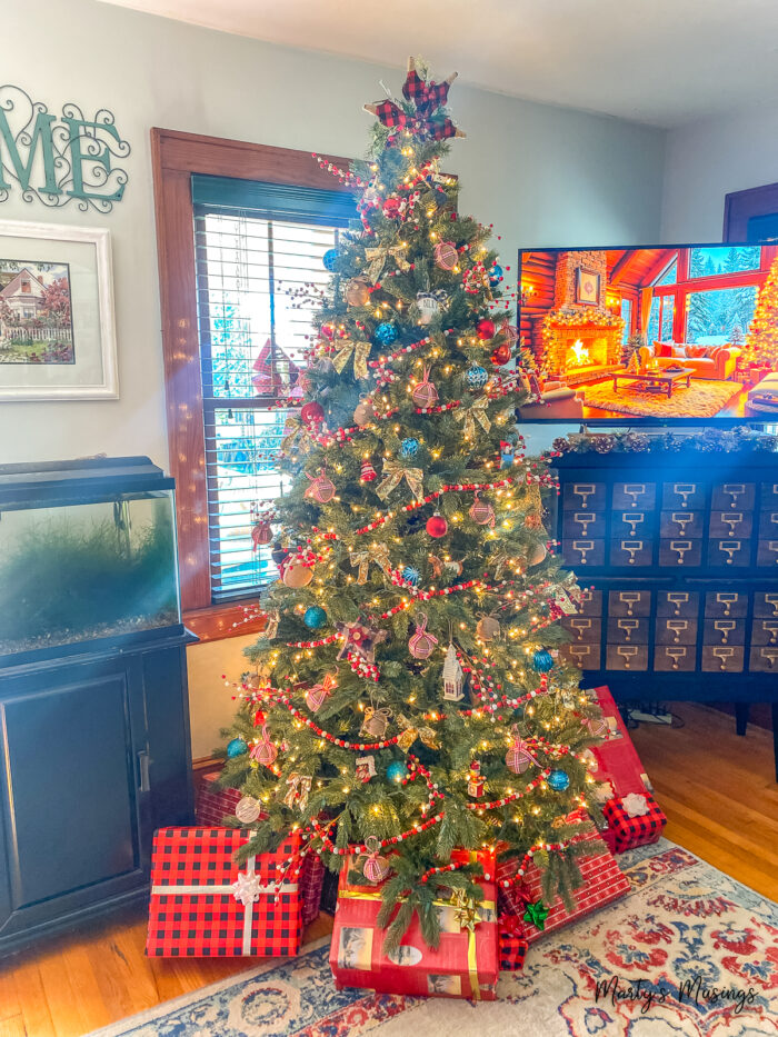 Árvore de Natal com decorações vermelhas xadrez buffalo e enfeites azuis