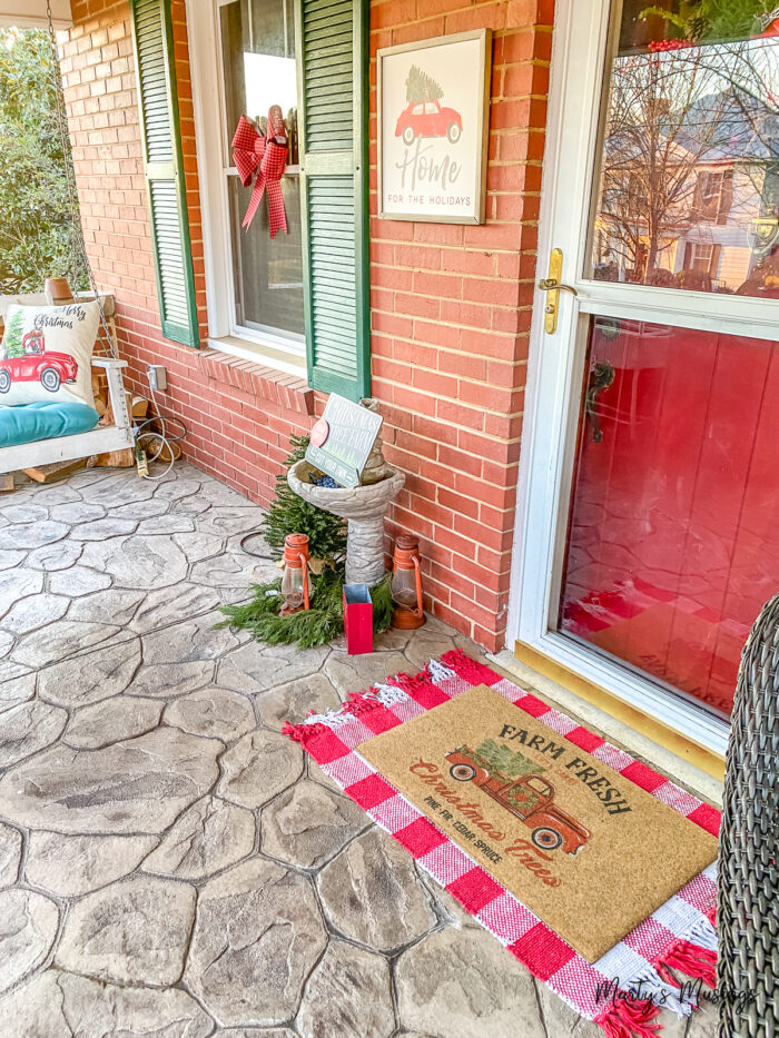 Varanda frontal de casa em estilo craftsman decorada para o Natal com xadrez buffalo vermelho