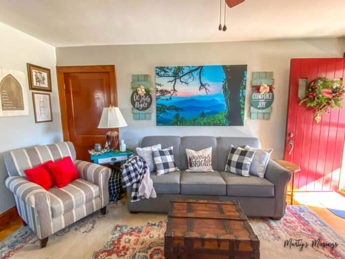 Sala de estar de casa em estilo craftsman decorada para o Natal com xadrez buffalo preto e branco e toques de vermelho