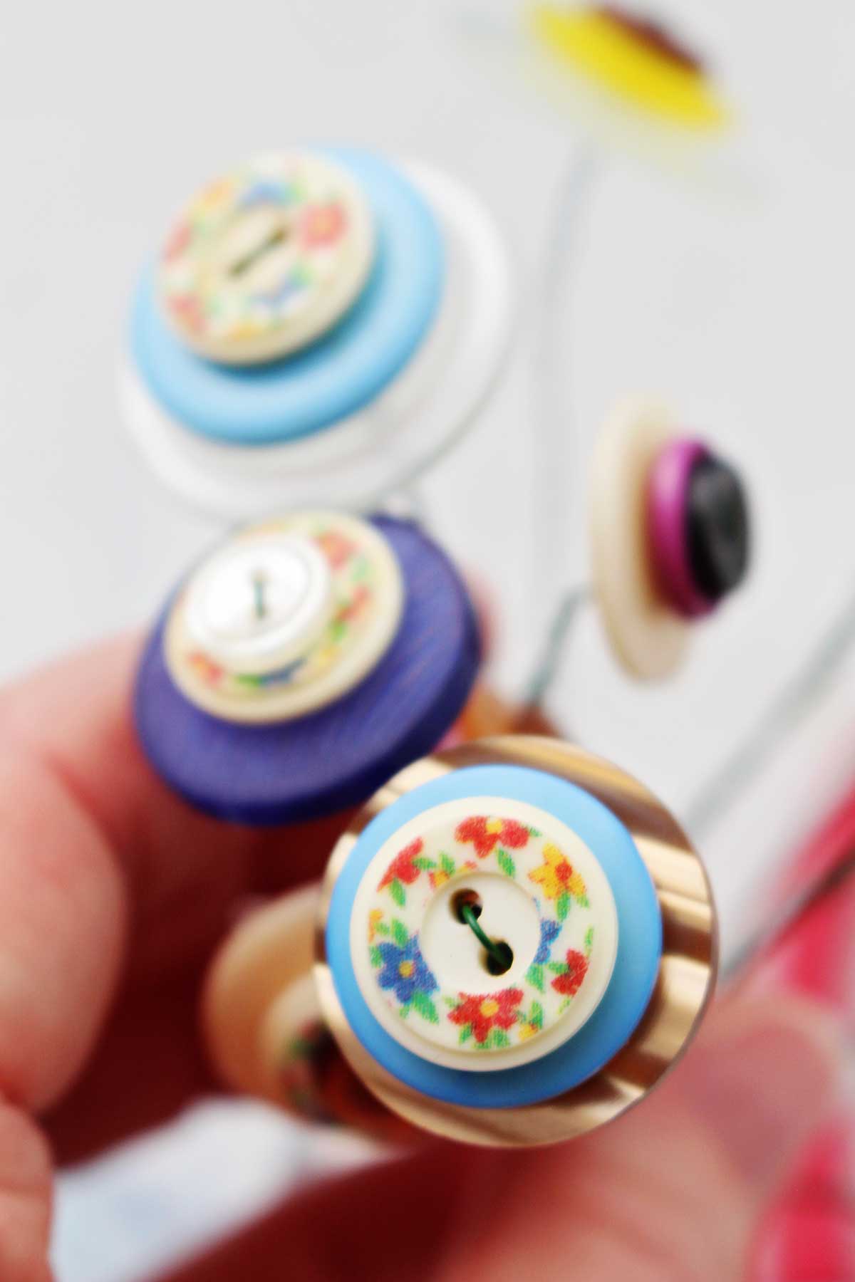 Close up de botões coloridos em camadas fixados com fio floral.