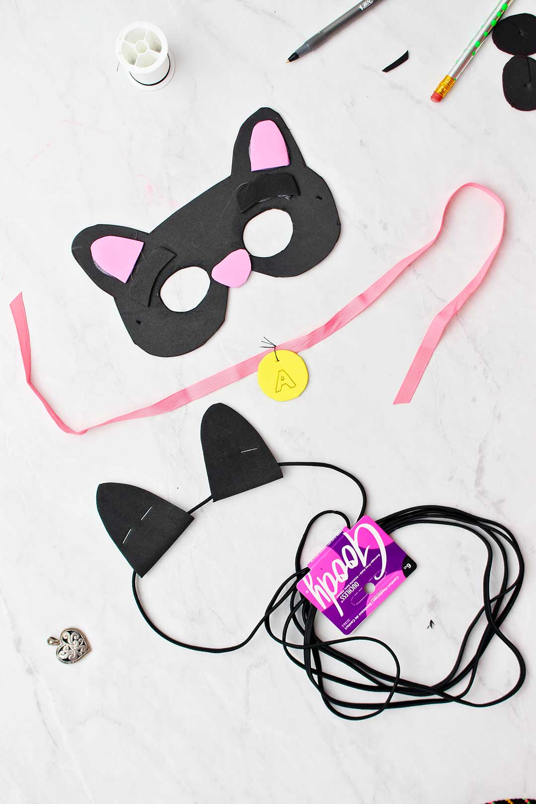 Máscara de gato preto, colar e orelhas feitas de espuma e elástico de cabelo preto.