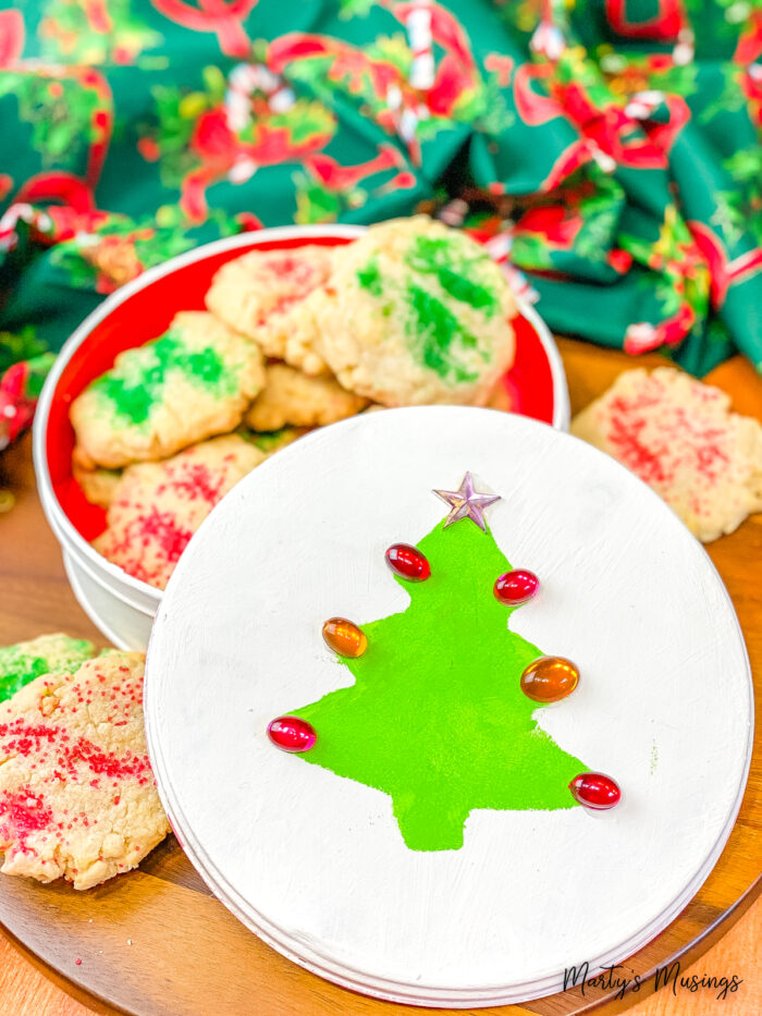 Árvore de Natal verde e pedras vermelhas em lata branca de Natal com biscoitos de açúcar