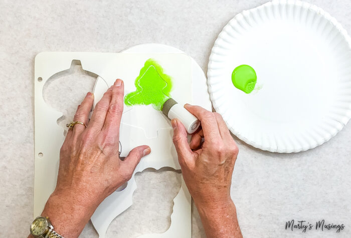 Aplicando carimbo com tinta verde e estêncil branco
